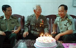 昭平县人武部领导文建坤（右）、梁盛华（左）与82岁的八路军老战士杨常文（中）话革命传统。